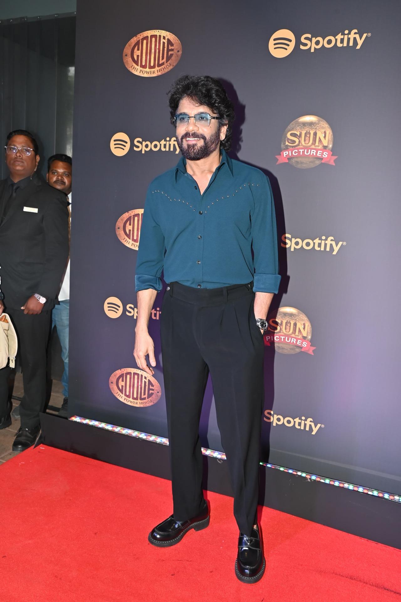 Telugu superstar Nagarjuna looked handsome as he came decked up in a teal green shirt and pants with black shoes. His teal sunglasses added a fun quotient to his otherwise formal look. He arrived for the music event of his upcoming film Coolie.